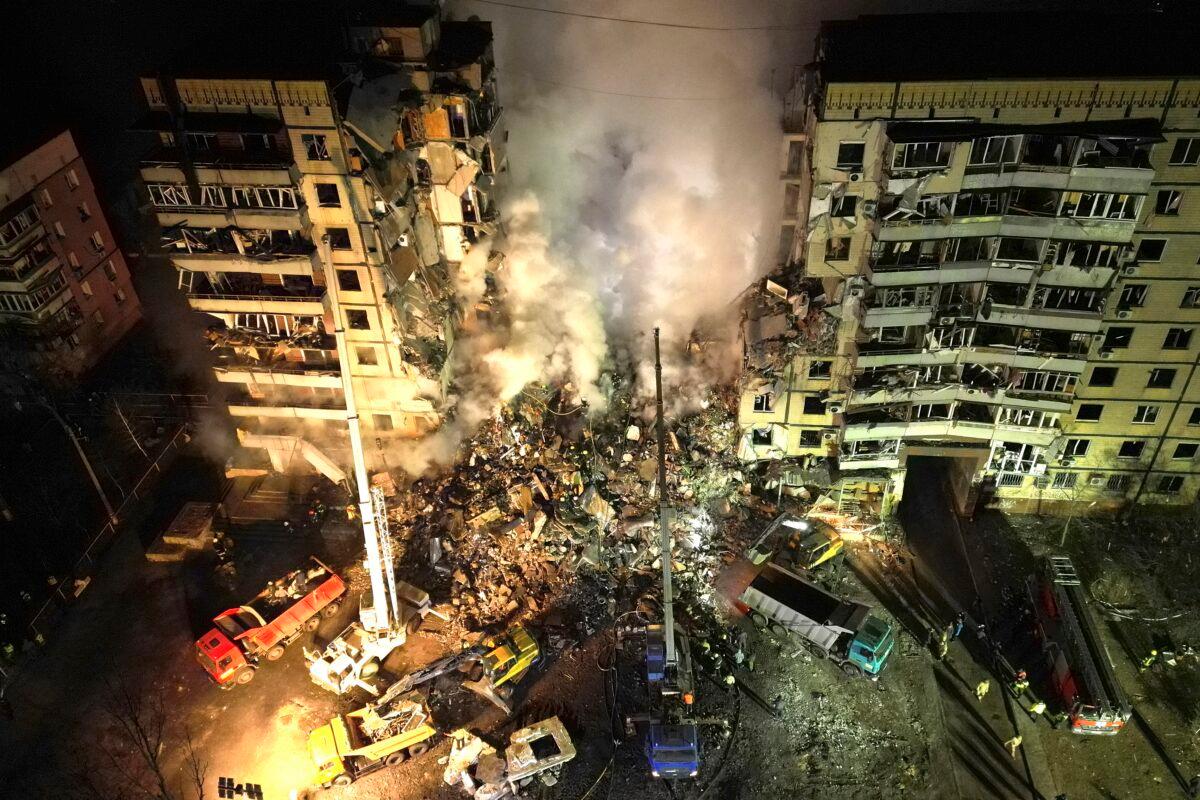 Emergency workers clear the rubble after a Russian rocket hit a multistory building leaving many people under debris in the southeastern city of Dnipro, Ukraine, on Jan. 14, 2023. (Evgeniy Maloletka/AP Photo)
