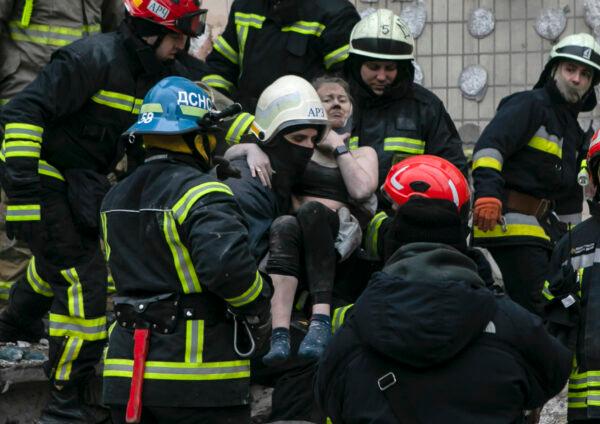 Emergency workers carry a wounded woman after a Russian rocket hit a multistory building on Saturday in Dnipro, Ukraine, on Jan. 15, 2023. (Yevhenii Zavhorodnii/AP Photo)