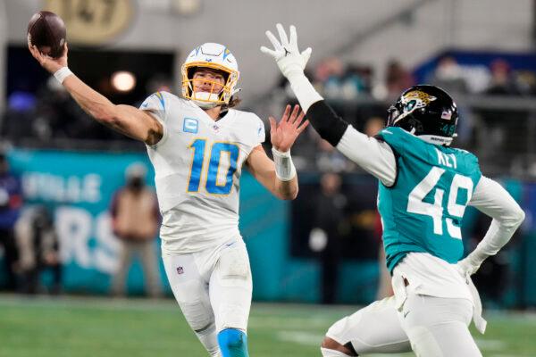Los Angeles Chargers quarterback Justin Herbert (10) throws under pressure by Jacksonville Jaguars defensive end Arden Key (49) during the second half of an NFL wild-card football game, in in Jacksonville, Fla., on Jan. 14, 2023. (Chris O'Meara/AP Photo)