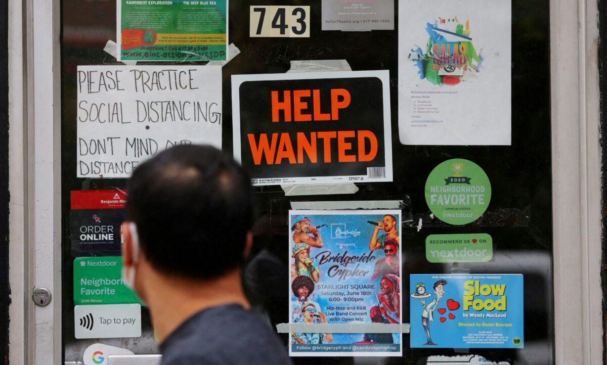 A pedestrian passes a "Help Wanted" sign in the door of a hardware store in Cambridge, Mass., on July 8, 2022. (Brian Snyder/Reuters)