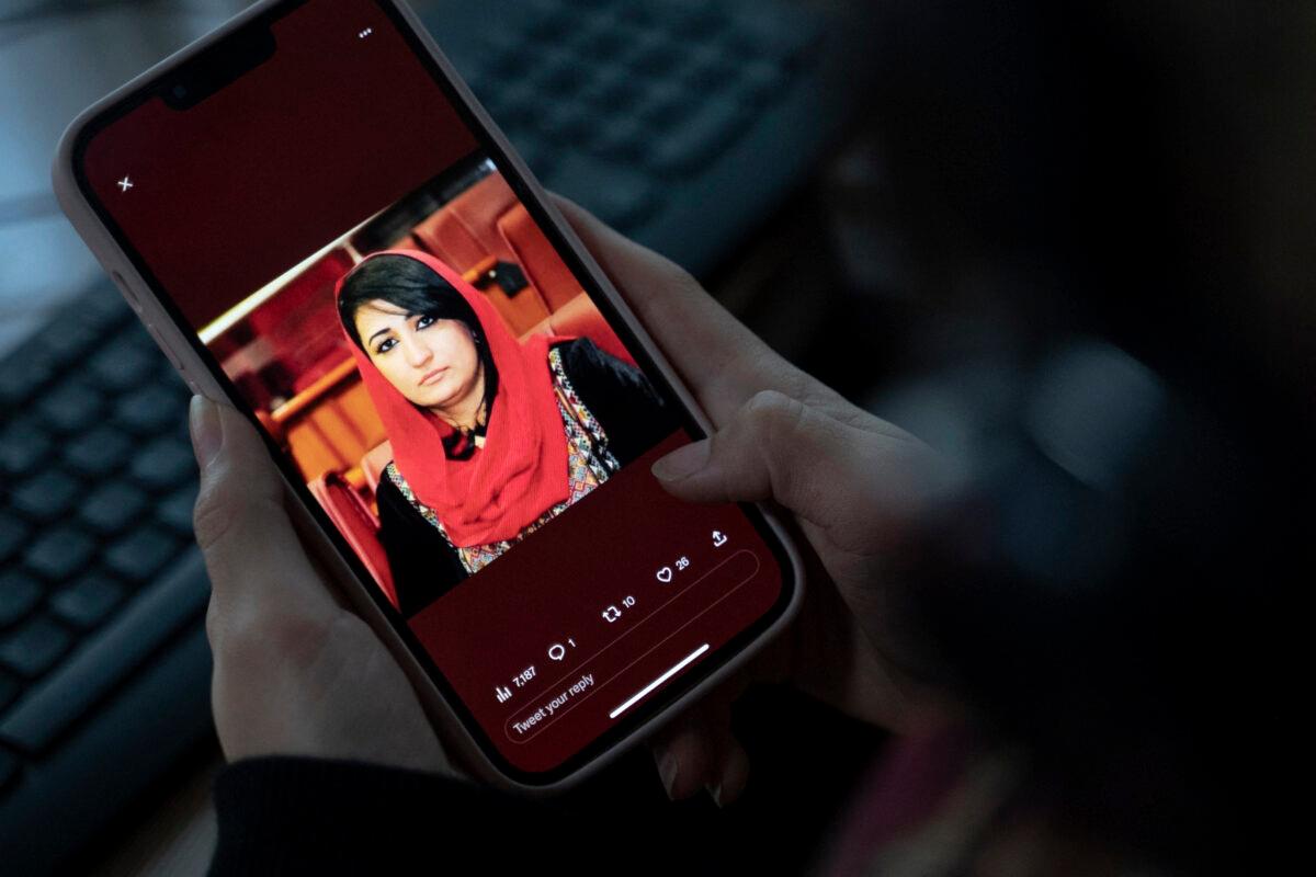 A woman looks at a picture of former Afghan lawmaker Mursal Nabizada on her mobile phone. Nabizada was shot dead by gunmen at her house in Kabul on Jan. 15, 2023. A member of parliament in the previous Western-backed regime, she was one of a few female government members who refused to flee Afghanistan when the Taliban seized power in August 2021. (Wakil Kohsar/AFP via Getty Images)