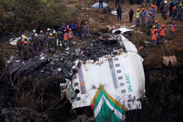 Rescuers scour the crash site in the wreckage of a passenger plane in Pokhara, Nepal, on Jan. 16, 2023. (Yunish Gurung/AP Photo)