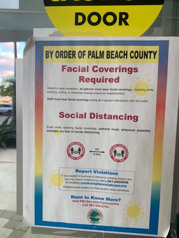 Signs encouraging people to report businesses and people violating rules related to COVID-19 were posted around Palm Beach County, Florida while David Kerner was mayor. (Courtesy of Chris Nelson)