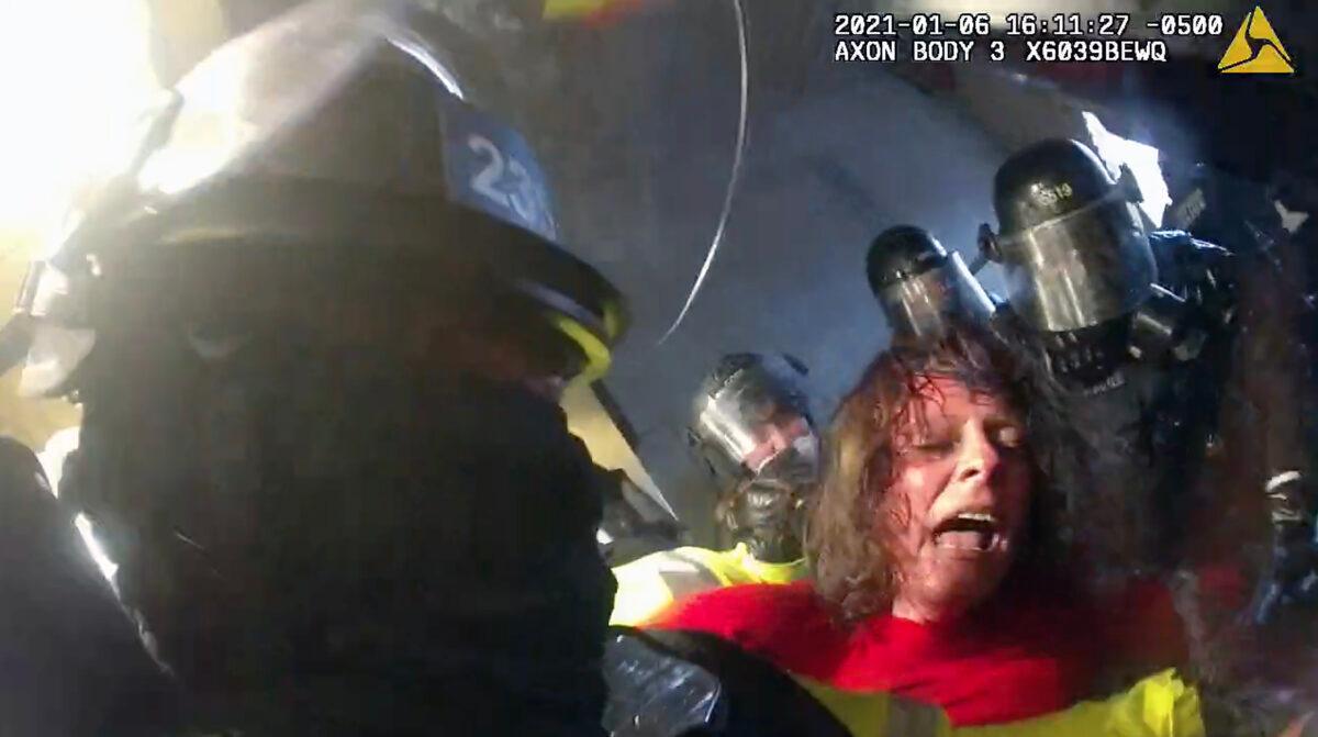 Victoria White is jostled and spun around by police in the Lower West Terrace tunnel at the U.S. Capitol on Jan. 6, 2021. (Metropolitan Police Department/Screenshot via The Epoch Times)