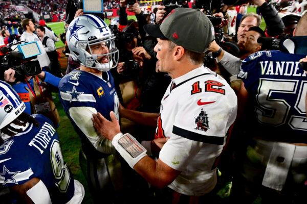 Dak Prescott (4) of the Dallas Cowboys and Tom Brady (12) of the Tampa Bay Buccaneers embrace on the field after their game in the NFC Wild Card playoff game at Raymond James Stadium in Tampa on Jan. 16, 2023. (Julio Aguilar/Getty Images)