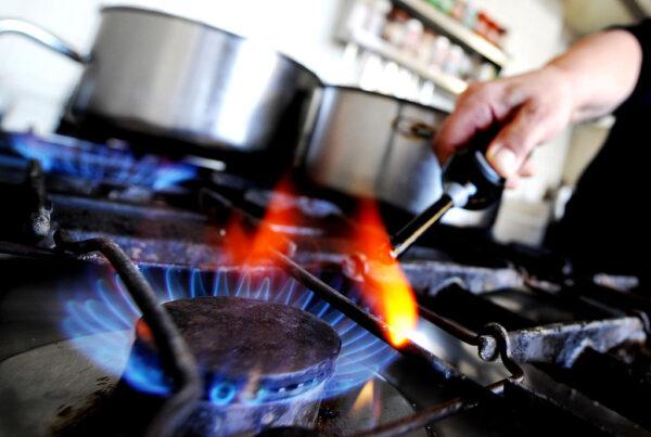 An Austrian hotel owner lights a gas stove to cook for customers in Puch bei Hallein on January 6, 2008. (Joe Klamar/AFP via Getty Images)