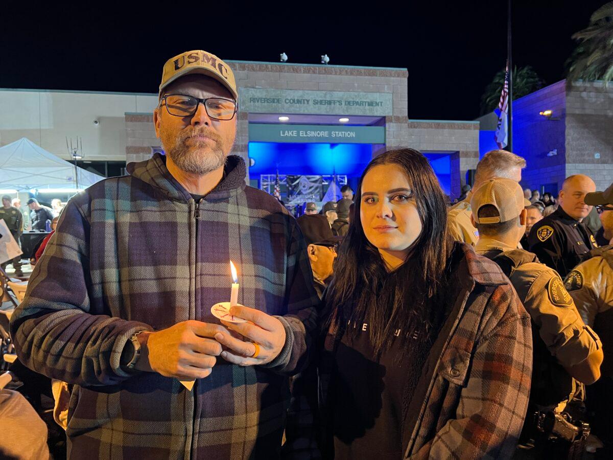 John Colvin and his daughter, Johanna Colvin, attend a vigil in honor of fallen Deputy Darnell Calhoun at the Riverside County Sheriff’s Department’s station in Lake Elsinore, Calif., on Jan. 17, 2023. (Brad Jones/The Epoch Times)
