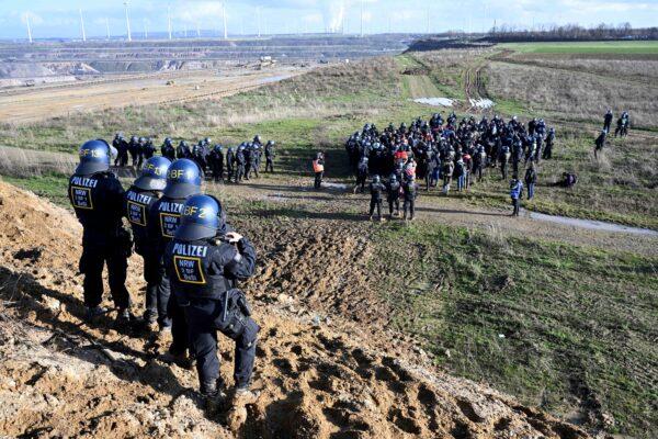 Police officers surround activists and coal opponents near the Garzweiler II lignite open pit mine during a protest following the clearance of the project in Luetzerath, Germany, on Jan. 17, 2023. (Federico Gambarini/dpa via AP)