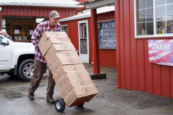 Chris Vreeland pushes boxes of yogurt and kefir at the Freedom Hill Farm in Otisville, N.Y., on Jan. 13, 2023. (Cara Ding/The Epoch Times)
