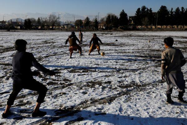 Afghan boys play football on the snow-covered ground at the Chaman-e-Huzori field in Kabul, Afghanistan, on Jan. 13, 2023. (Ali Khara/Reuters)