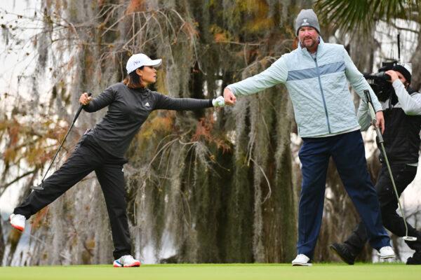 Danielle Kang of the United States and Derek Lowe fist bump after putting on the 18th green during the final round of the 2022 Hilton Grand Vacations Tournament of Champions at Lake Nona Golf & Country Club in Orlando, Fla., on Jan. 23, 2022. (Julio Aguilar/Getty Images)