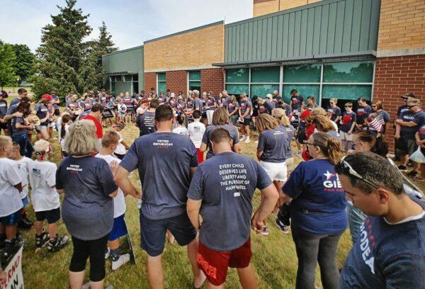 Ottawa Impact activists pause to pray before going to campaign in the Independence Day parade in Allendale Township on July 4, 2022. (Courtesy of Ottawa Impact)