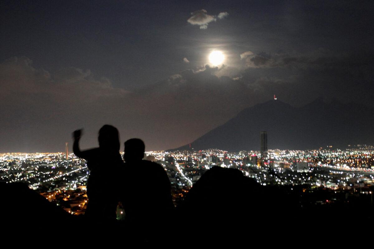 A supermoon rises while a couple takes a photo in Monterrey, Mexico, on Aug. 10, 2014. (Daniel Becerril/Reuters)