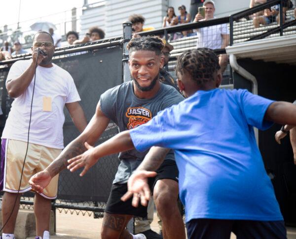 Buffalo Bills' Damar Hamlin high fives his little brother Damir Hamlin, 7, during a celebrity kickball game with all proceeds going to the Pittsburgh Promise scholarship fund which provides college tuition to local high school graduates, at George Cupples Stadium in Pittsburgh on June 25, 2022. (Maya Giron/Pittsburgh Post-Gazette via AP)