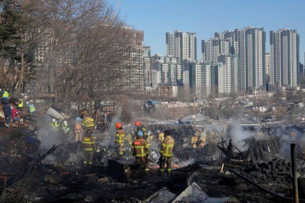 Firefighters and rescue workers clean up the site of a fire at Guryong village in Seoul, South Korea, on Jan. 20, 2023. (Ahn Young-joon/AP Photo)