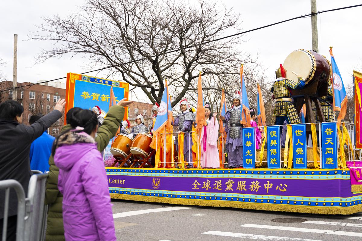 Bystanders wave at Falun Gong practitioners' arrays in the Chinese New Year parade in Flushing, N.Y., on Jan. 21, 2023. (Chung I Ho/The Epoch Times)