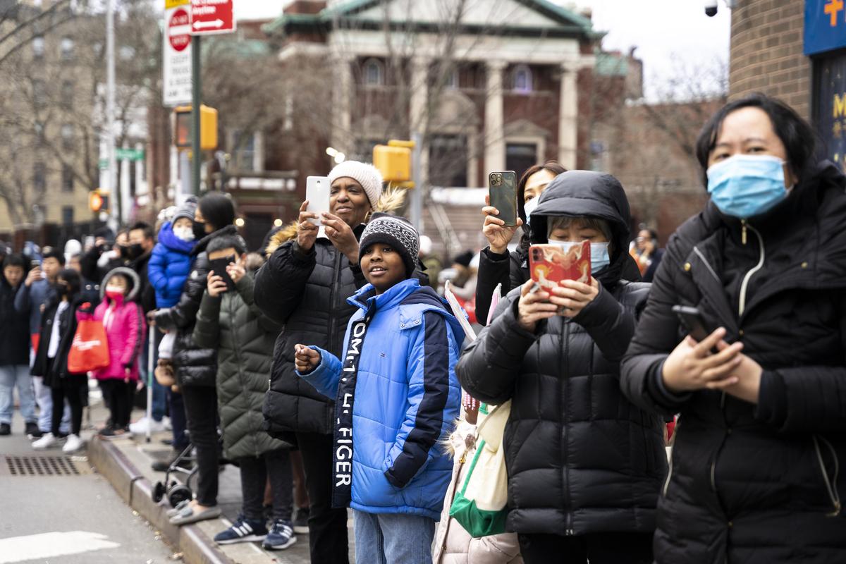 Bystanders watch Falun Gong practitioners participate in the Chinese New Year parade in Flushing, N.Y., on Jan. 21, 2023. (Chung I Ho/The Epoch Times)