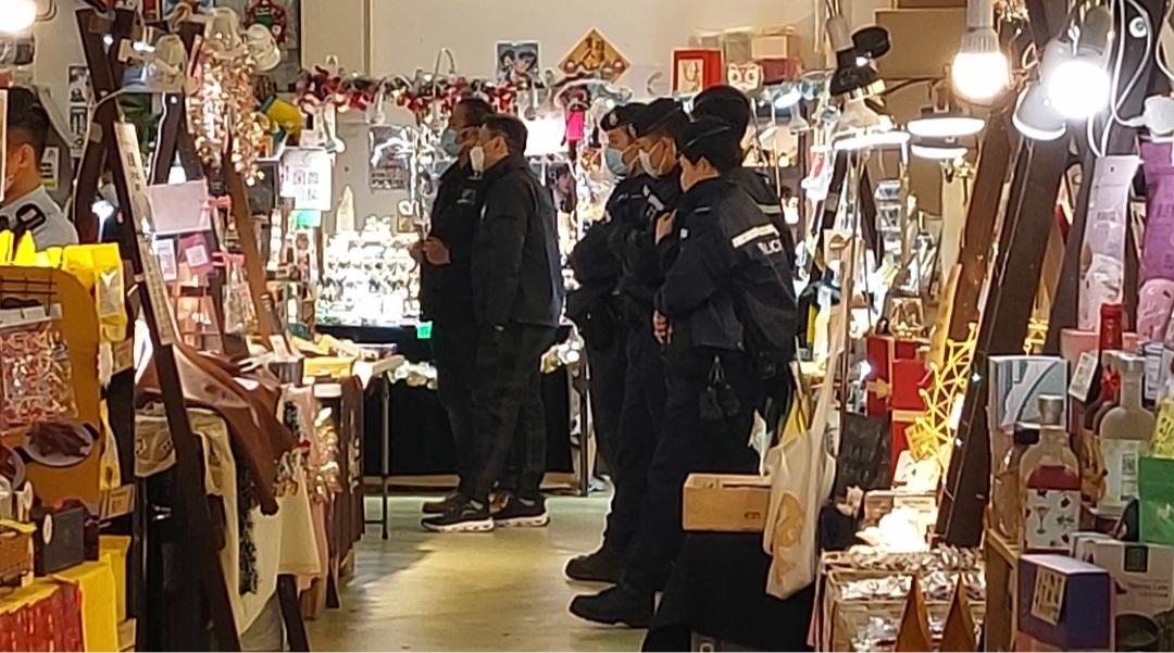 The police officers, some wearing uniforms printed with NSD, and customs officers inside the booth in question.  on Jan. 17, 2023. (Big Mack/The Epoch Times)