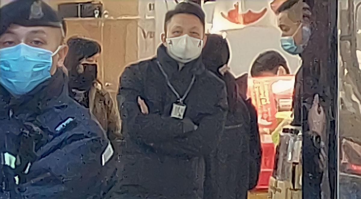 The police officers, some wearing uniforms printed with NSD, and customs officers inside the booth in question.  on Jan 17, 2023. (Big Mack/The Epoch Times)