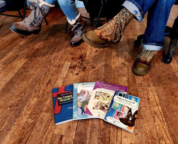 Several books on healing veterans with Post Traumatic Stress Disorder are spread on the floor at Operation: Transition Outside the Wire in Williams, Ariz., on Jan. 16, 2023. (Allan Stein/The Epoch Times)