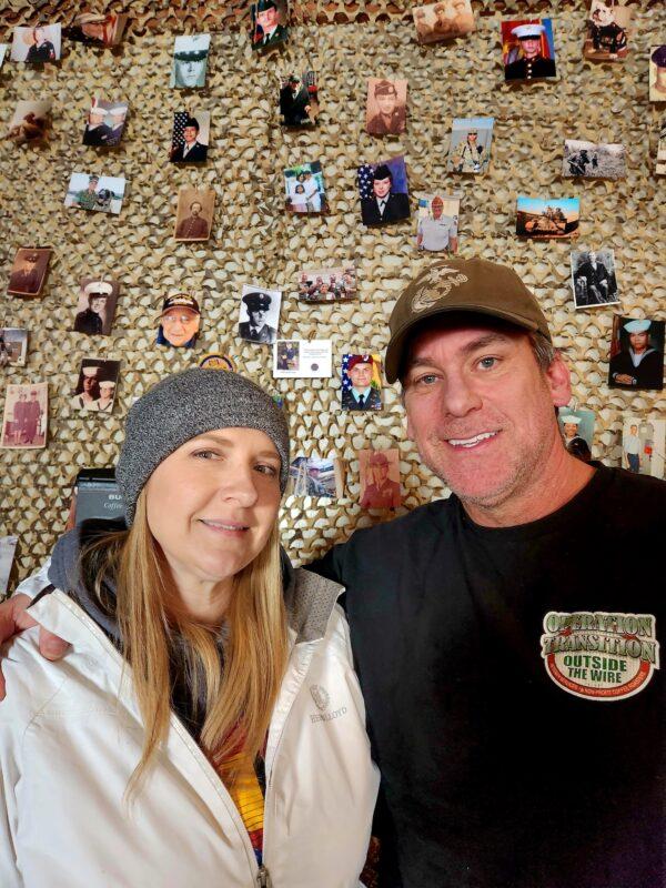 Shannon Francis and Tom West, co-founders of Operation: Transition Outside the Wire, stand in front of a wall filled with pictures of veterans they've known or helped in Williams, Ariz., on Jan. 16, 2023. (Allan Stein/The Epoch Times)