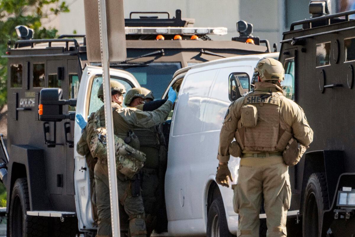 Members of a SWAT team enter a van and look through its contents in Torrance, Calif., on Jan. 22, 2023. (Damian Dovarganes/AP Photo)