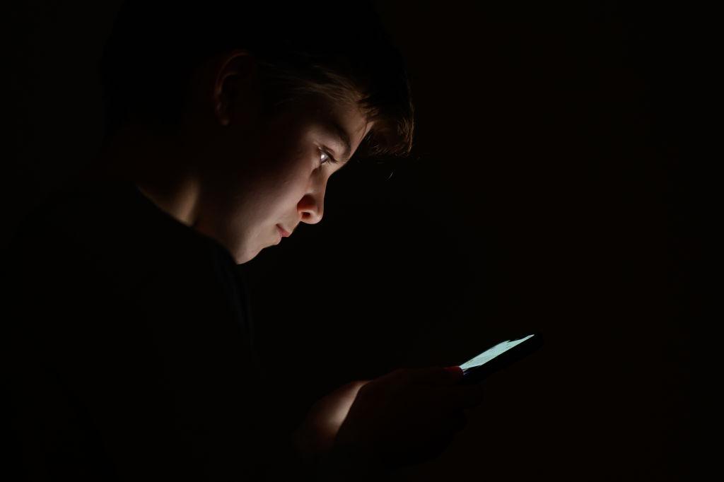 A teenage child looks at the screen of a mobile phone in London, on Jan. 17, 2023. (Leon Neal/Getty Images)