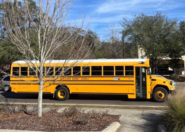 A school bus rolls down the street in Gainesville, Fla., after school on Jan. 23, 2023. (Nanette Holt/The Epoch Times)