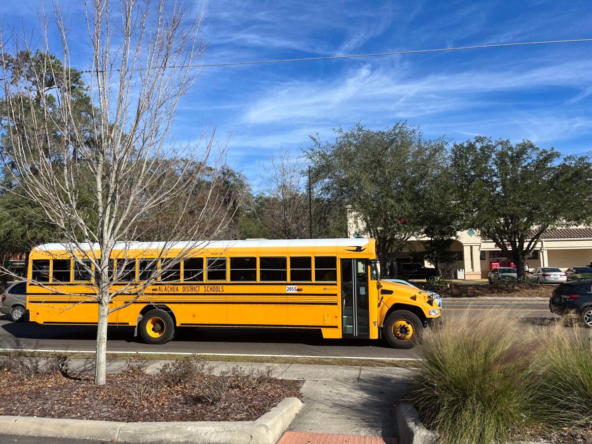 A school bus rolls down the street in Gainesville, Fla., after school on Jan. 23, 2023. (Nanette Holt/The Epoch Times)