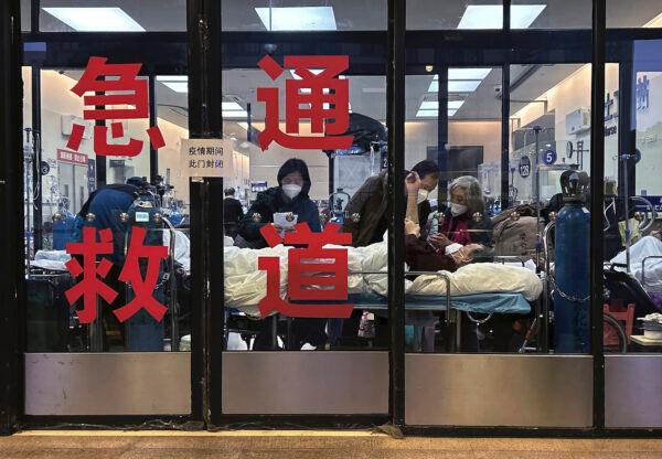Patients and caregivers are seen in the closed entranceway of an emergency room being used as an overflow area at a hospital in Shanghai, China, on Jan. 14, 2023. (Kevin Frayer/Getty Images)