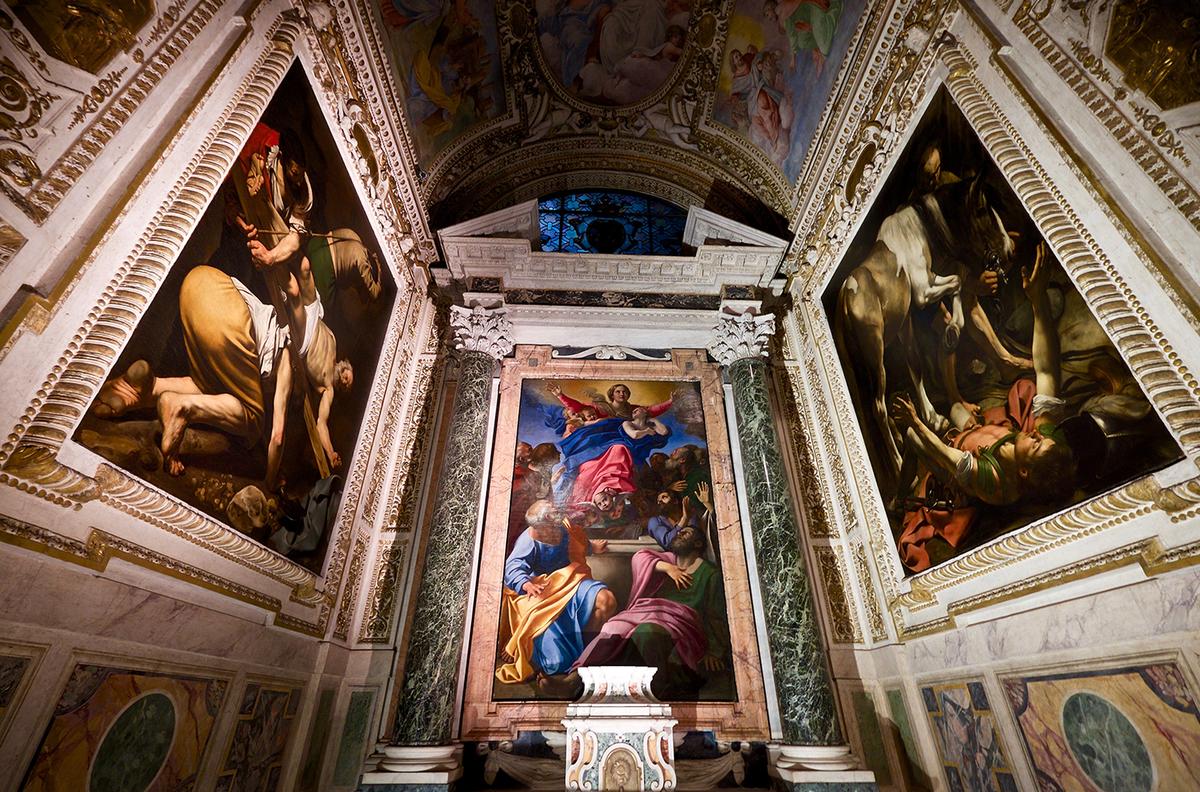 Caravaggio painted "Crucifixion of Saint Peter" (L) and "Conversion on the Way to Damascus," along the side walls of the chapel, but the altarpiece (C) “Assumption of the Virgin” was painted by Rome’s most established artist, Annibale Carracci. Basilica of Santa Maria del Popolo, Rome. (<a href="https://commons.wikimedia.org/wiki/File:Annibale_Carracci_e_Caravaggio,_Cappella_Cerasi.jpg">Frederick Fenyvessy</a>/<a href="https://creativecommons.org/licenses/by/2.0/deed.en">CC BY 2.0</a>)