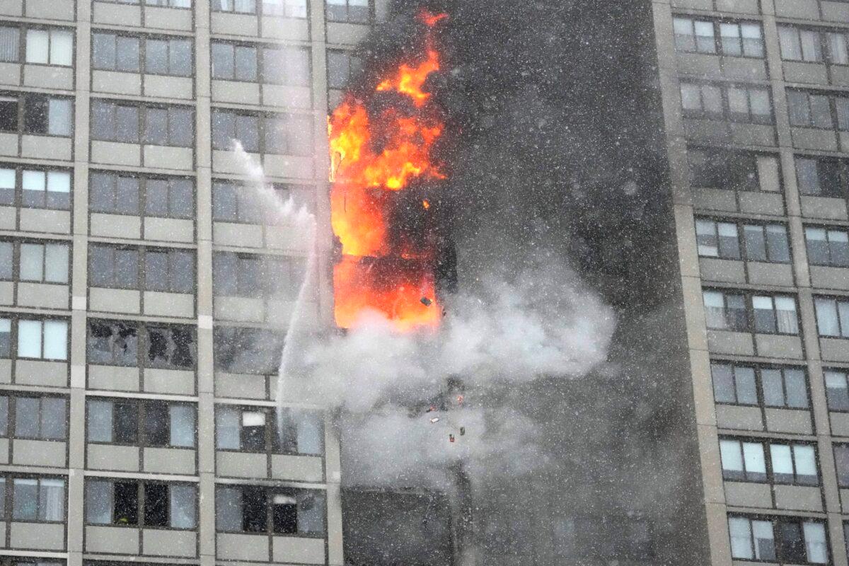 Flames leap skyward out of the Harper Square cooperative residential building in the Kenwood neighborhood of Chicago on Jan. 25, 2023. (Charles Rex Arbogast/AP Photo)