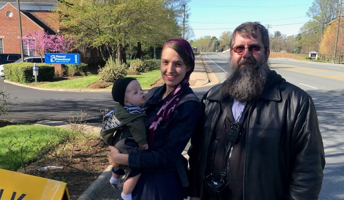 Denny Green with his daughter Charity and his grandson Hudson on the sidewalk in front of a Planned Parenthood abortion facility in Charlottesville, Va., in 2021. (Courtesy of Denny Green)
