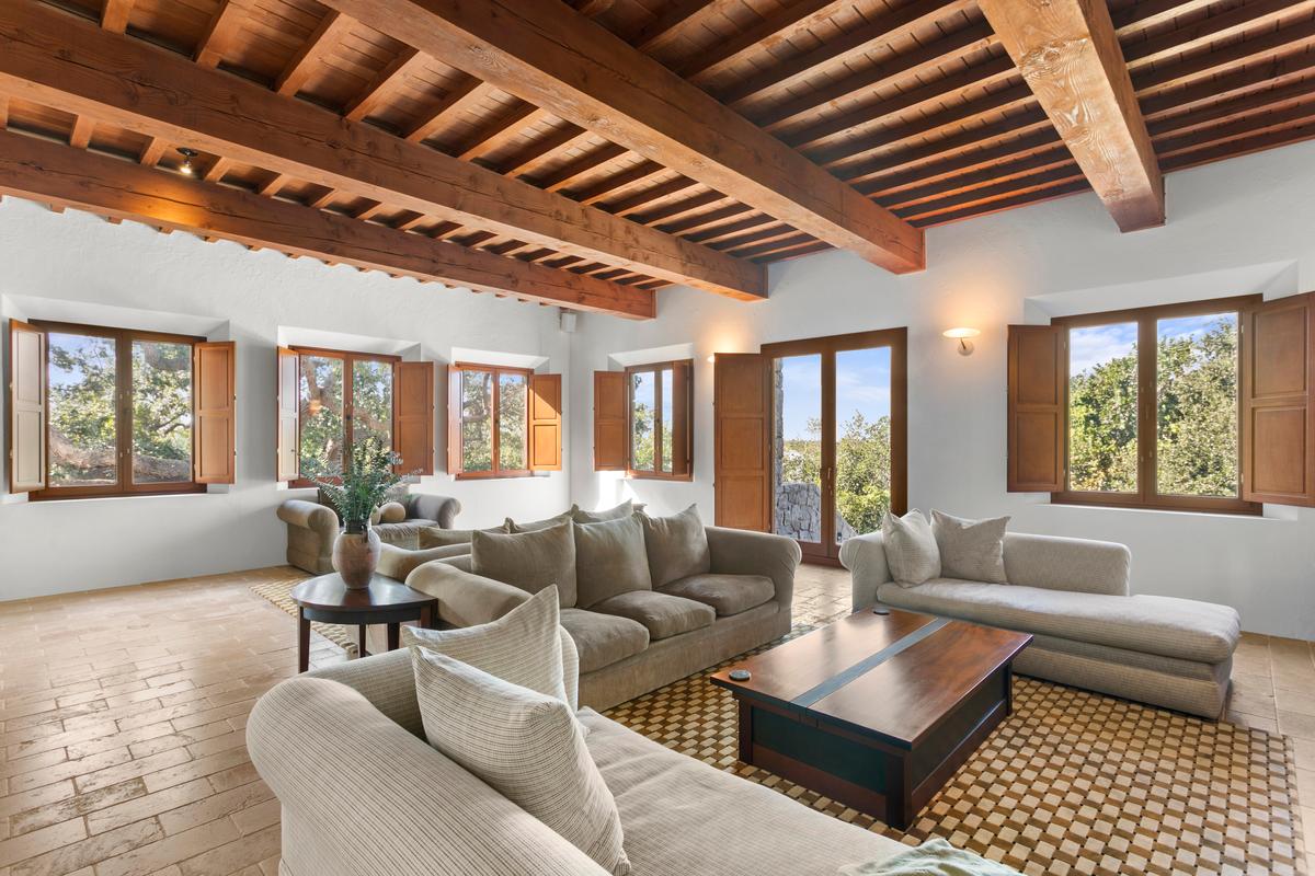 The living room, accented with exposed Douglas fir beams, tile floors, and large windows to bring the outside in, is an ideal place for family and guests to relax and enjoy each other’s company. (Courtesy of Sica Media)