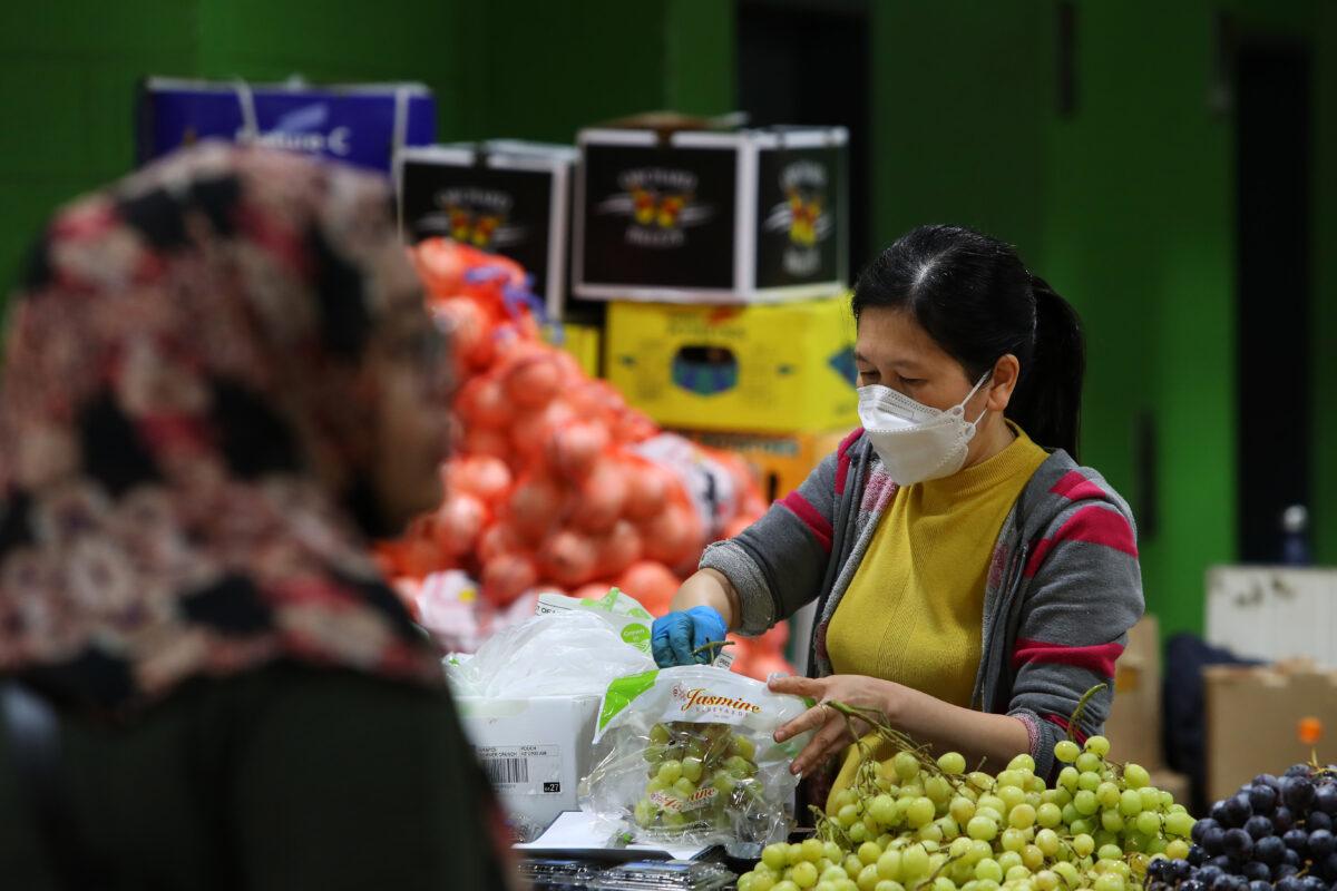A store worker prepares grapes for sale at Paddy's Market in Sydney, Australia, on Oct. 22, 2022. (Lisa Maree Williams/Getty Images)