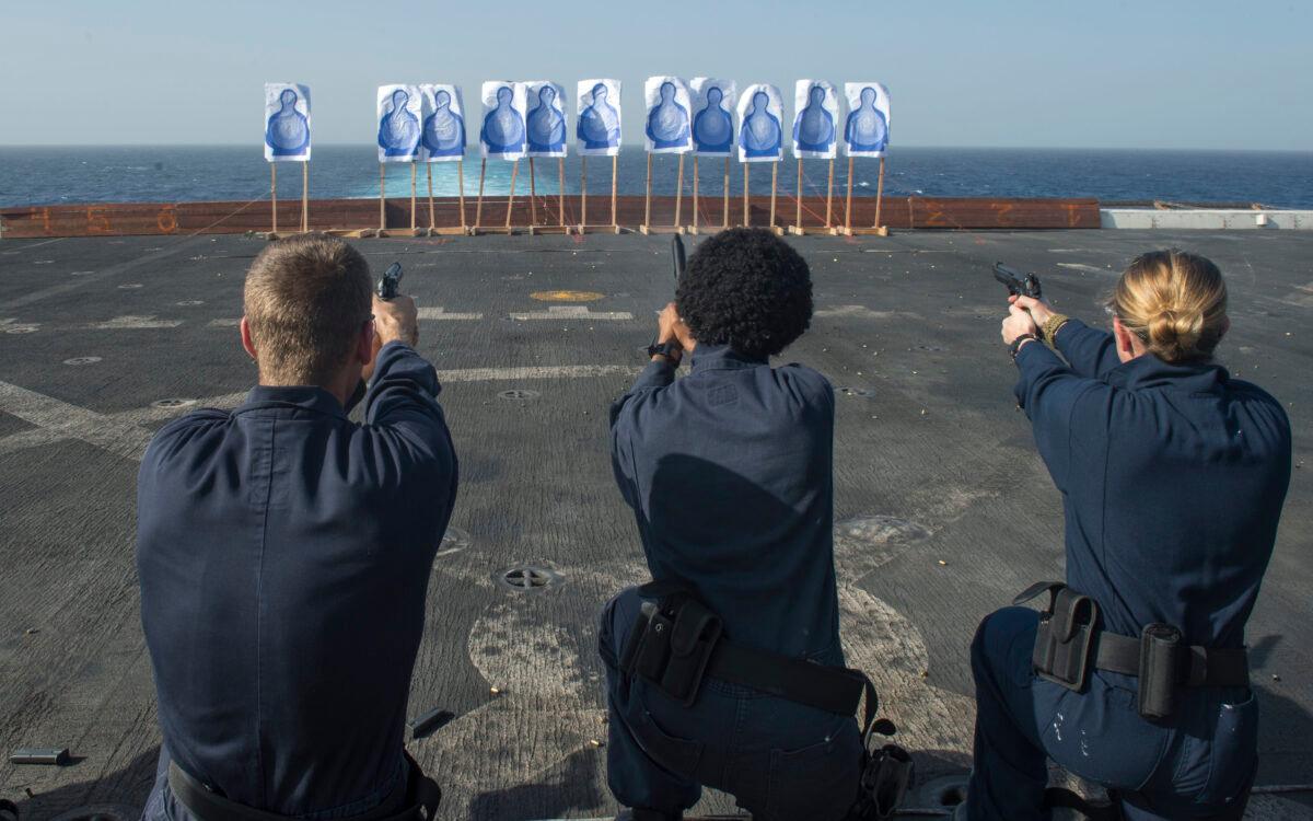 Sailors assigned to the amphibious transport dock ship USS San Diego (LPD 22) fire 9mm handguns from the kneeling position during a live-fire exercise on the flight deck of the ship. The San Diego is part of the Makin Island Amphibious Ready Group and, with the embarked 11th Marine Expeditionary Unit, is deployed in support of maritime and theater security operations in the U.S. 5th Fleet area of responsibility. (U.S. Navy Mass Communication Specialist 2nd Class Stacy M. Atkins Ricks)