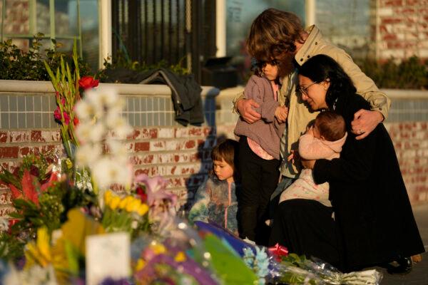 A family gathers at a memorial outside the Star Ballroom Dance Studio in Monterey Park, Calif., on Jan. 24, 2023. (Ashley Landis/AP Photo)