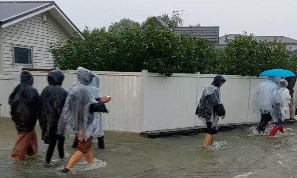People walk on a flooded street after Elton John's concert was canceled due to bad weather in Auckland, New Zealand, on Jan. 27, 2023. (Duane Moyle/via Reuters)