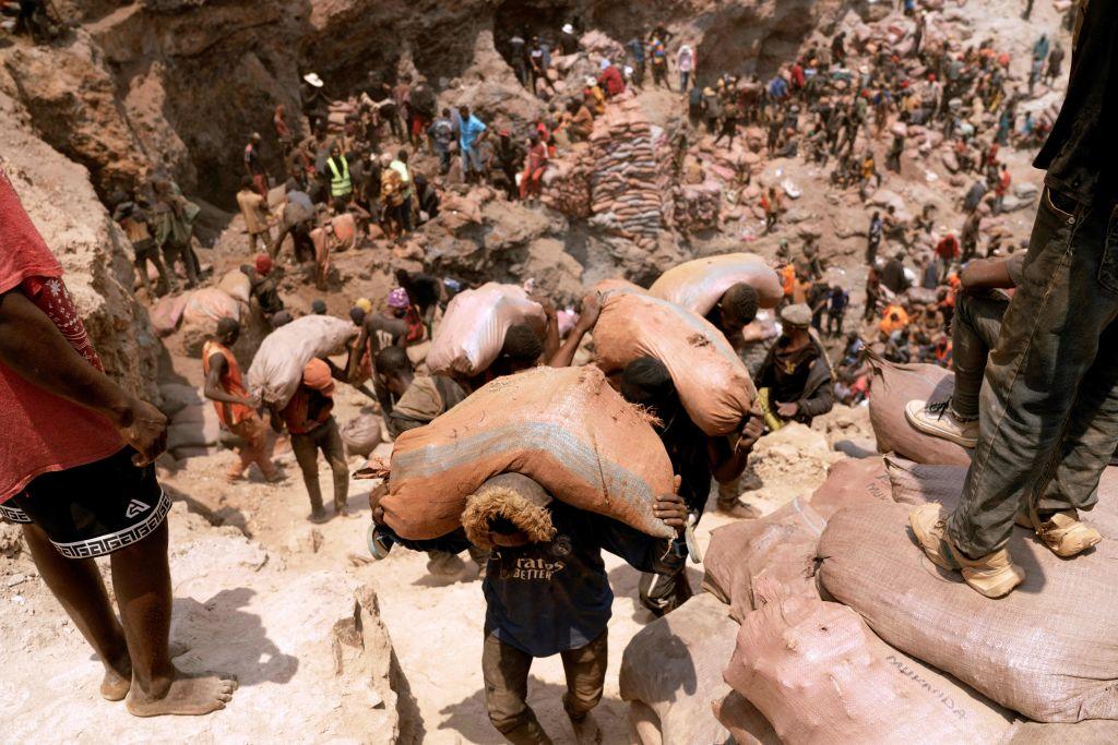 Artisanal miners carry sacks of ore at the Shabara artisanal cobalt mine near Kolwezi on Oct. 12, 2022. Demand for the metal is exploding due to its use in the rechargeable batteries that power mobile phones and electric cars. (Junior Kannah/AFP via Getty Images)