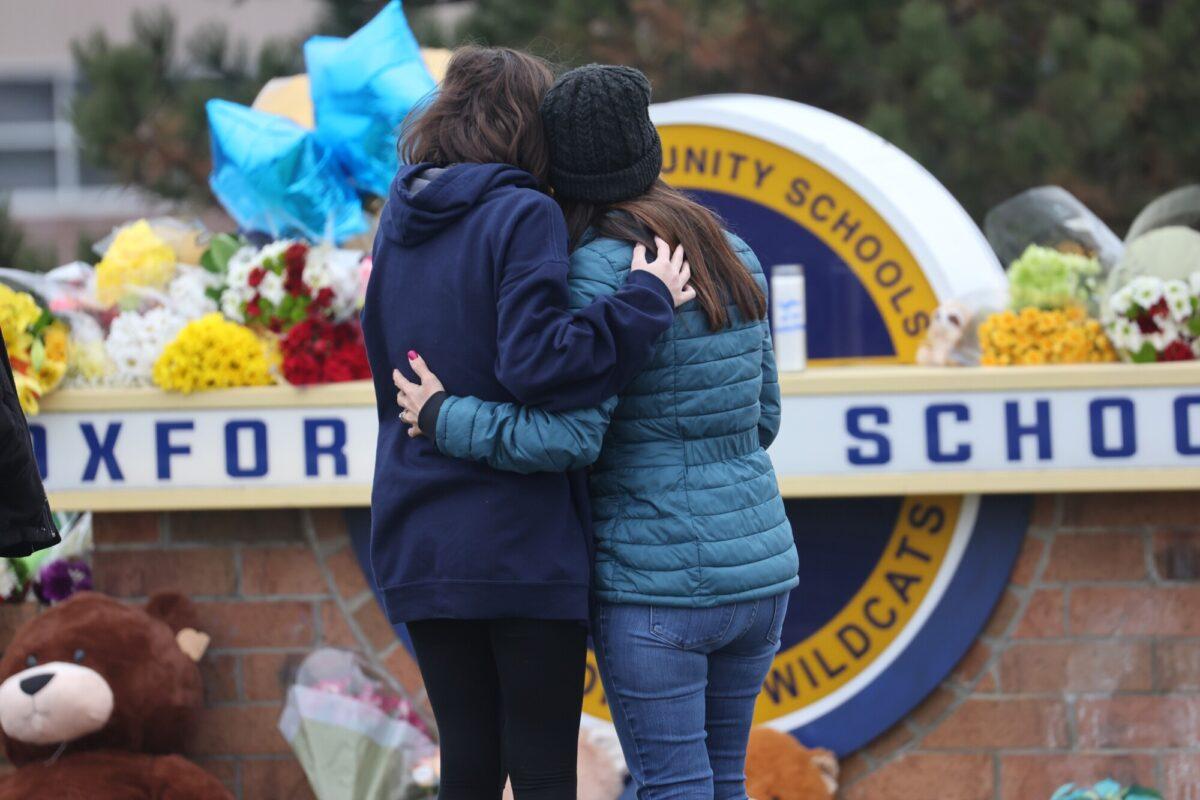 People embrace as they visit a makeshift memorial outside of Oxford High School,, in Oxford, Mich., on Dec. 1, 2021. (Scott Olson/Getty Images)