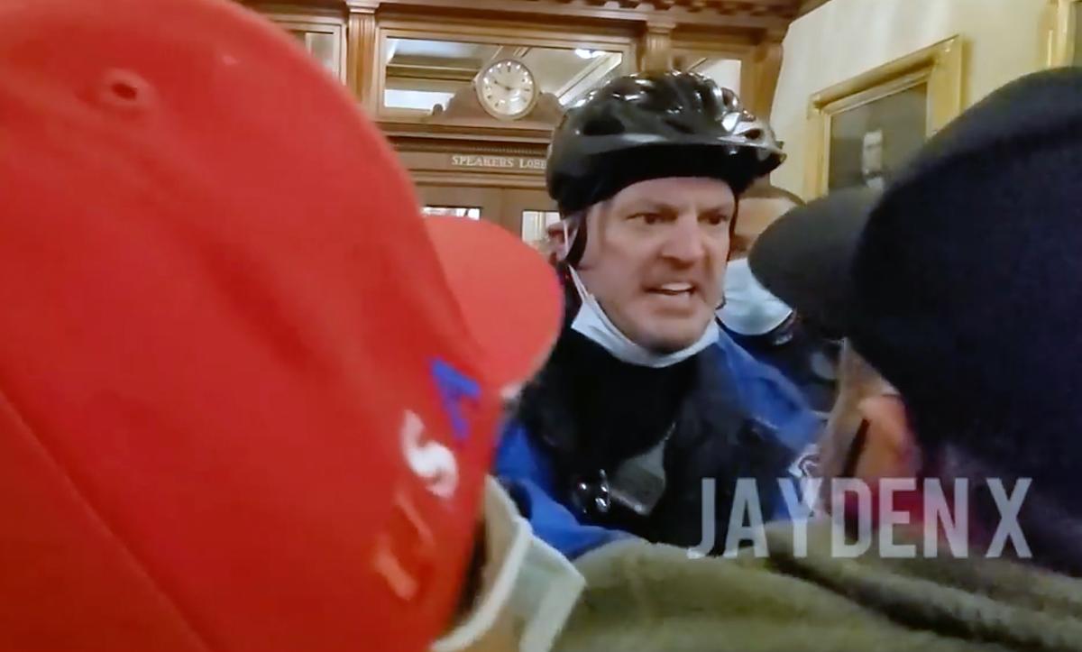A U.S. Capitol Police officer (C) shoves Dr. Austin Harris (lower right) down the hallway outside the Speaker's Lobby at the U.S. Capitol on Jan. 6, 2021. (Jayden X/Screenshot via The Epoch Times)