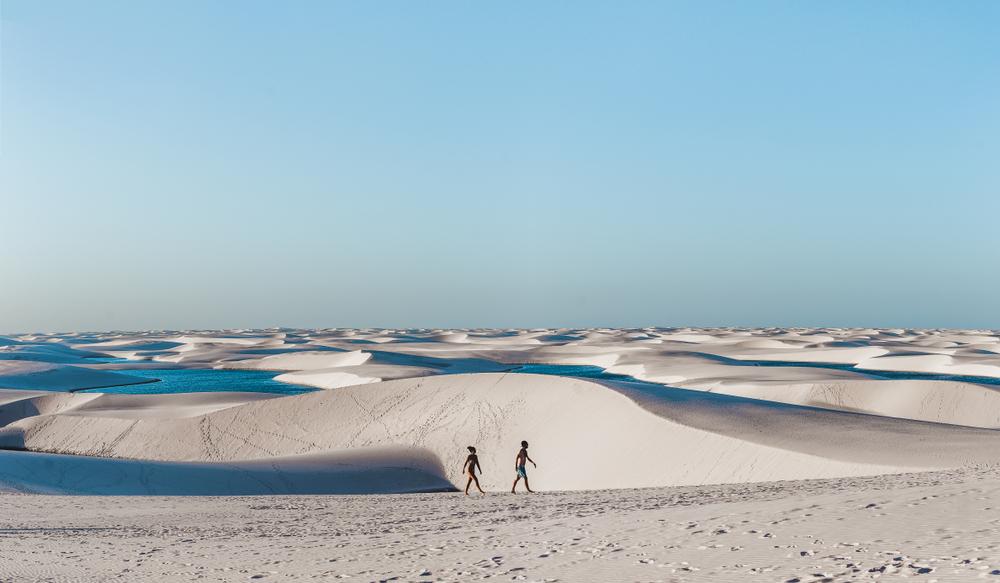 Visitors walk the warm sands amid the lagoons at Lençóis Maranhenses. (Lauren Squire/Shutterstock)