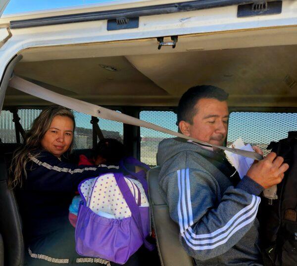 An illegal migrant family from Colombia waits inside a U.S. Border Patrol vehicle at the southern border wall in San Luis, Ariz., on Jan. 27, 2023. (Allan Stein/The Epoch Times)
