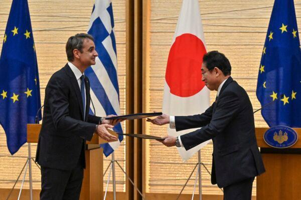 Greek Prime Minister Kyriakos Mitsotakis (L) exchanges documents with Japanese Prime Minister Fumio Kishida during their joint press conference following their meeting at the prime minister's official residence in Tokyo on Jan. 30, 2023. (Richard A. Brooks/Pool Photo via AP)