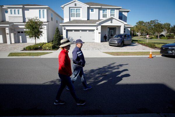 A couple walks in front of the house where former Brazilian President Jair Bolsonaro is staying in Kissimmee, Fla., on Jan. 11, 2023. (Marco Bello/Reuters)