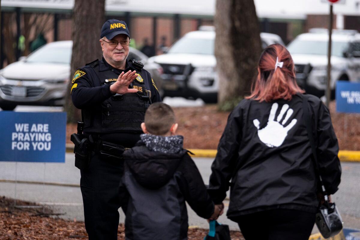 Sgt Jamie Huling of the Newport News Police Department greets students as they return to Richneck Elementary in Newport News, Va., on Jan. 30, 2023. (Billy Schuerman/The Virginian-Pilot via AP)