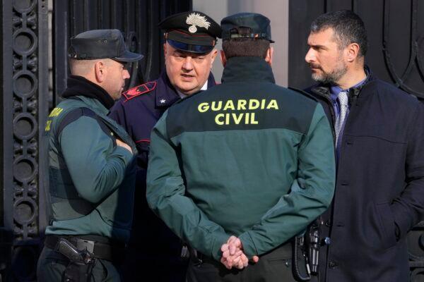 Spanish Civil Guards speak with an Italian embassy employee at the gates of the Italian embassy in Madrid on Jan. 31, 2023. (Paul White/AP Photo)