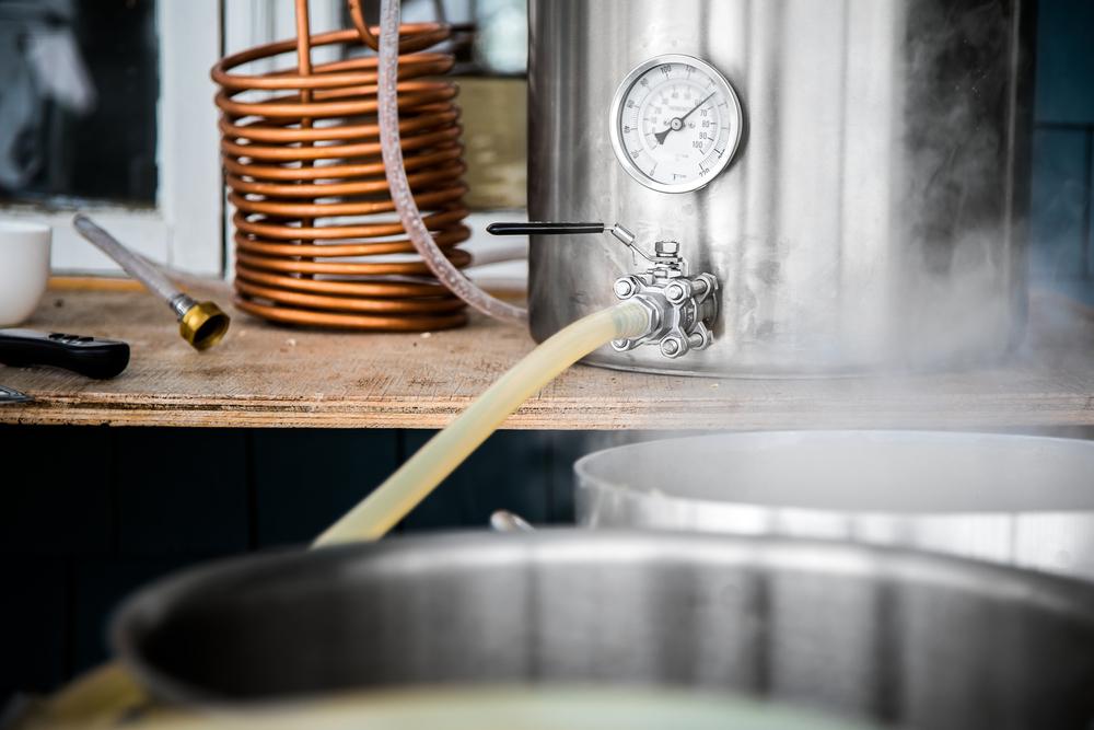 After the wort has been boiled, it's allowed to cool, water is added, an initial specific gravity reading is taken, yeast is added, and it's transferred to bottles for final fermentation. (Benoit Daoust/Shutterstock)