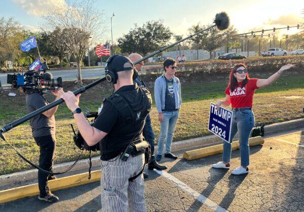 With a handful of fellow Trump supporters waving to passing cars, former Republican congressional candidate Laura Loomer—an outspoken opponent of Florida Gov. Ron DeSantis—talks with reporters near a book-signing by DeSantis in Leesburg, Fla., on Feb. 28, 2023. (Nanette Holt/The Epoch Times)