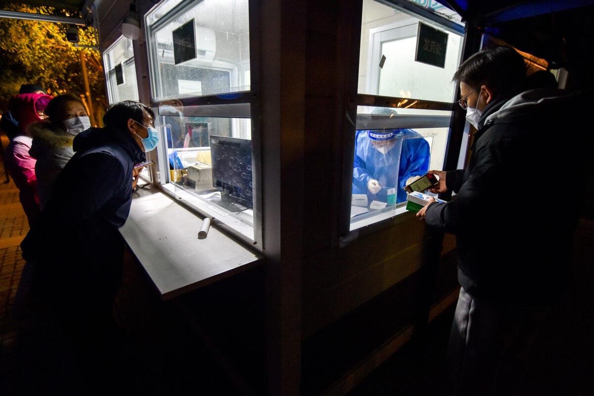 People get medicine at the window of a night diagnosis and treatment station in Nanjing, Jiangsu Province, China, on Dec. 27, 2022. (CFOTO/Future Publishing via Getty Images)